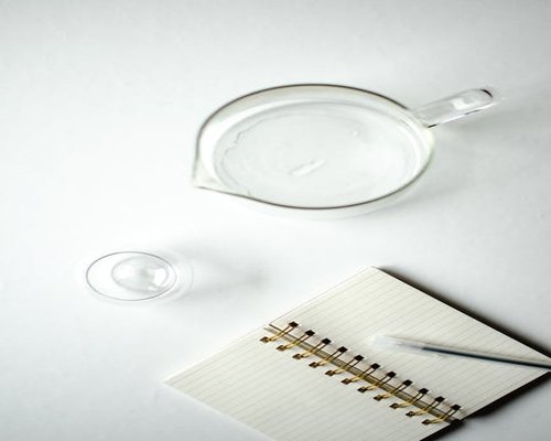 A clean desk with a glass of water and notebook for day planning