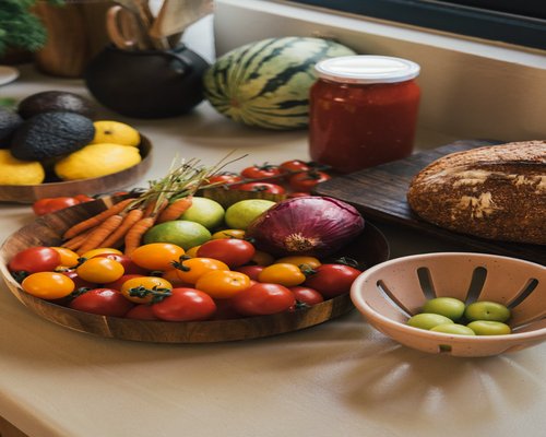 Fresh colorful vegetables and fruits arranged on a kitchen table